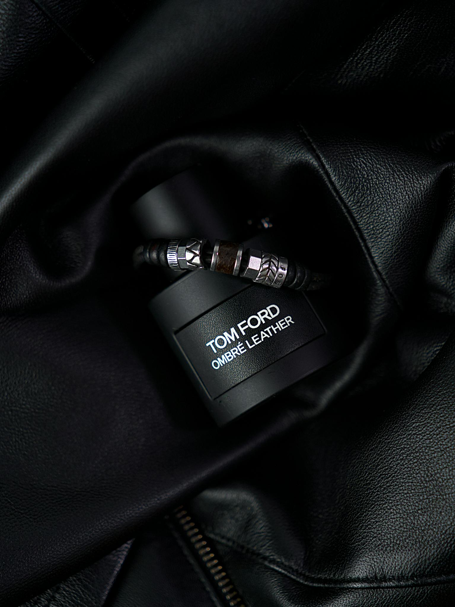 Luxury Tom Ford Ombré Leather fragrance bottle styled on dark leather backdrop.